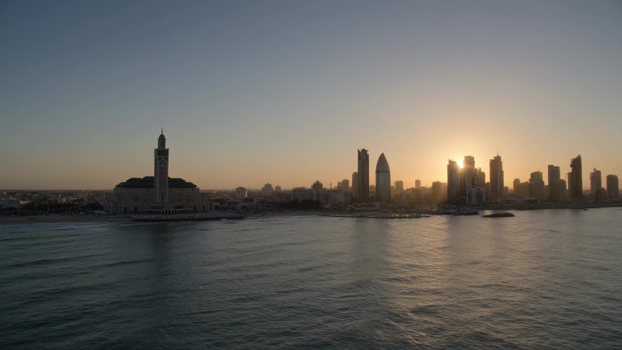 Le skyline de Casablanca au lever du jour — la Mosquée Hassan II et les tours du centre d'affaires, face à l'océan